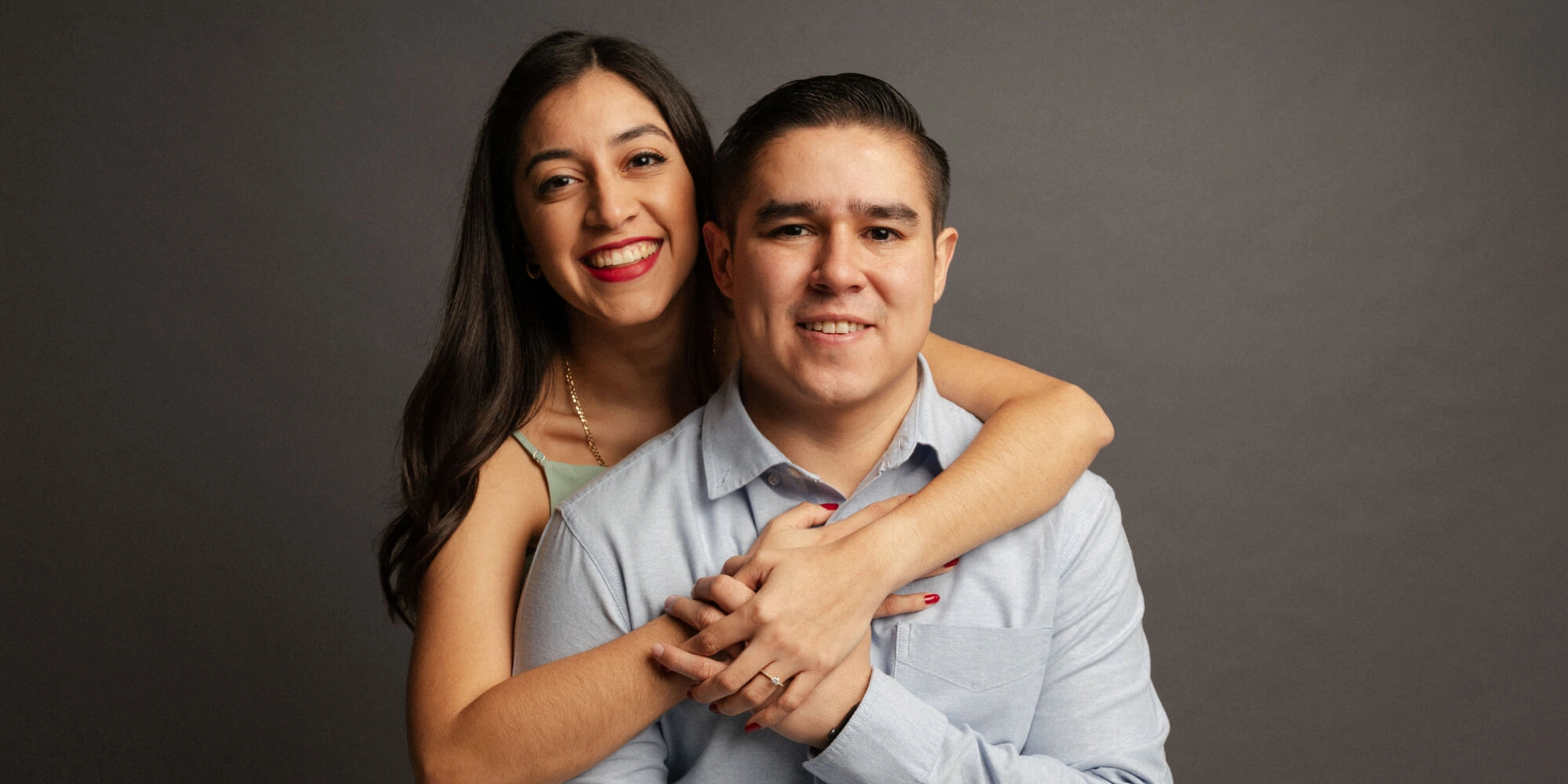Pareja de novios abrazados en sesión de fotos de estudio para su boda.